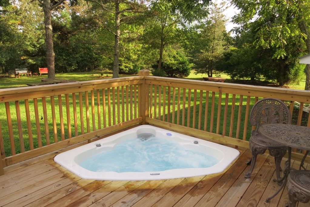 A jacuzzi beside a table and a chair