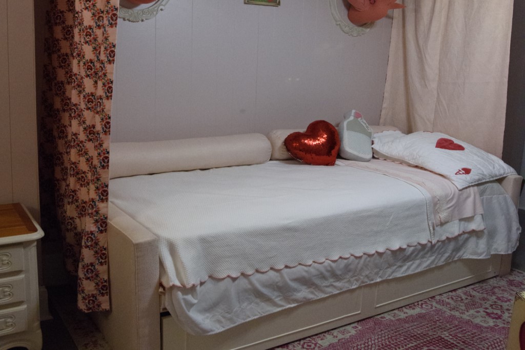A Bed With a White Bed Cover and a Heart Shaped Pillow